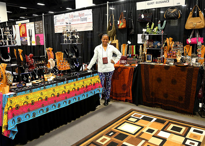 photo of a jewelry artist at exhibit booth